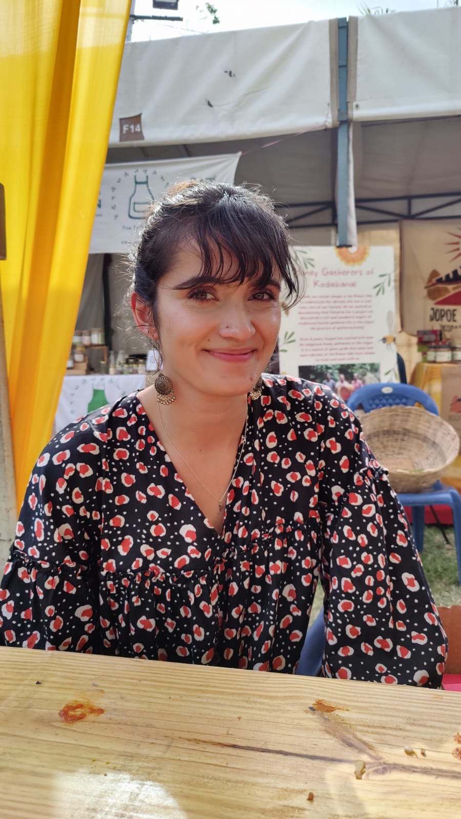 Headshot of smiling woman in an orange and black dress.